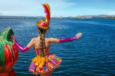 Peru 'nun Puno kentindeki Uros ve Titicaca Gölü adasında, Candelaria festivalinin tipik kostümünü giymiş güzel bir dansçı.