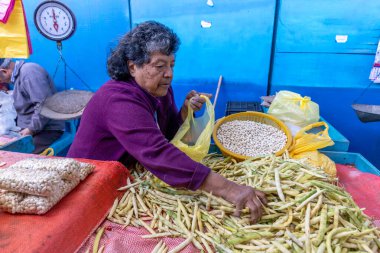 Kadın pazarda taze mısır satıyor.