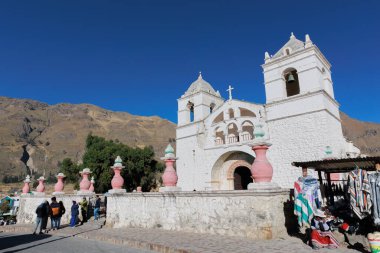 Turistler Colca Vadisi 'ndeki Akbaba' nın bakış açısını ziyaret ediyorlar. Maca meydanında el işi ve alpaka satıyorum. Arequipa Peru