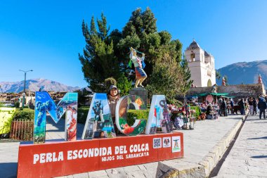 Turistler Colca Vadisi 'ndeki Akbaba' nın bakış açısını ziyaret ediyorlar. Maca meydanında el işi ve alpaka satıyorum. Arequipa Peru