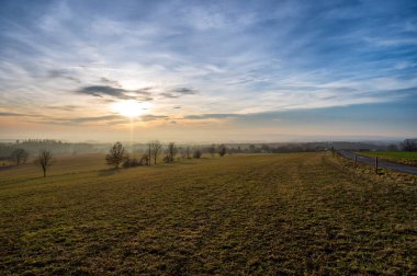 Bulutların üzerinde altın gün batımı. Karsız kış zamanı.