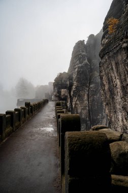 Awesome Autumn Landscape. Amazing misty Morning in Saxon Switzerland National Park near Dresden at the Elbe river. Unsurpassed sunrise in the mountains Saxon Switzerland. Exciting nature scene clipart