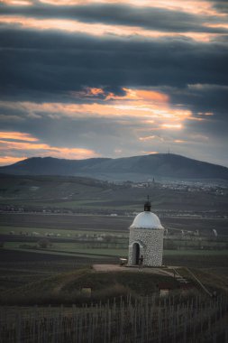 Beautiful sunset at chapel Hradistek with sun and clouds in background near Velke Bilovice Czech Republic clipart