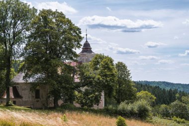 Catholic church in a Czech village Kacerov, Orlicke mountains. Summer wiew with dramatic clouds. clipart