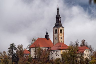 Slovenya 'nın en ünlü alp gölü (Blejsko jezero) yoğun siste, inanılmaz sisli arazisinde. Gölün manzarası, adanın kilisesi ve sudaki yansıması, dış seyahat arka planı.
