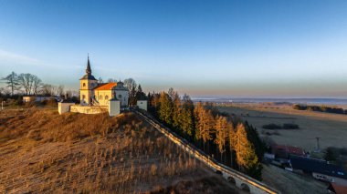 Old place of pilgrimage Homole in Eastern Bohemia, long stone stairs with statues leading to the church, Czech Republic. Aerial view.