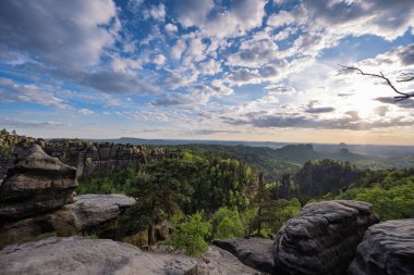 Almanya 'da Carolafelsen, kumtaşı uçurumundan Saksonya İsviçre' nin derin sisli vadisine güzel bir akşam manzarası. Kumtaşı zirveleri sisli arka plandan yükseldi. Vahşi doğada akşam manzarası..