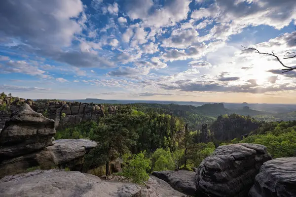 Almanya 'da Carolafelsen, kumtaşı uçurumundan Saksonya İsviçre' nin derin sisli vadisine güzel bir akşam manzarası. Kumtaşı zirveleri sisli arka plandan yükseldi. Vahşi doğada akşam manzarası..