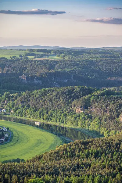 Günbatımı, Lilienstein 'da görüldüğü gibi Sakson İsviçre' nin verimli bahar manzarasına ılık bir ışıltı yayar. Tarlalar ve ormanlar genişliyor, dingin ve görkemli bir zemin oluşturuyor..