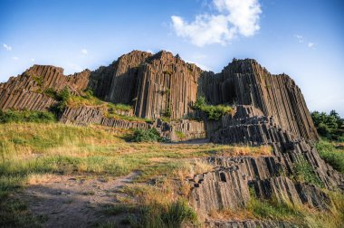 Herrnhausfelsen olarak da adlandırılan bazalt sütunların çokgen yapılarına, Prachen (Çek Cumhuriyeti) yakınlarındaki doğal anıt Panska skala 'ya bakınız. Bazalt alışılmadık bir volkanik kayadır..