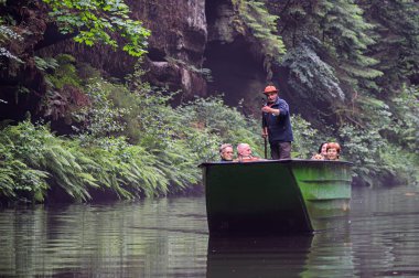 Hrensko, Çek Cumhuriyeti - 24 Haziran 2021: Edmunds 'taki turizm teknesi Bohemian İsviçre' deki Kamenice nehri üzerinde, Çek Cumhuriyeti 'nin çeşitli kaya oluşumlarıyla nehir kanyonunda popüler turistik ilgi merkezi