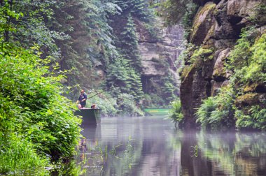 Hrensko, Çek Cumhuriyeti - 24 Haziran 2021: Edmunds 'taki turizm teknesi Bohemian İsviçre' deki Kamenice nehri üzerinde, Çek Cumhuriyeti 'nin çeşitli kaya oluşumlarıyla nehir kanyonunda popüler turistik ilgi merkezi