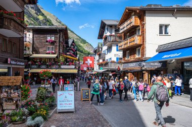 ZERMATT, SWitzERLAND - 26 Ağustos 2021: İsviçre 'nin Valais kantonundaki Zermatt kasabasının merkezindeki geleneksel yerel evler ve dükkanlar