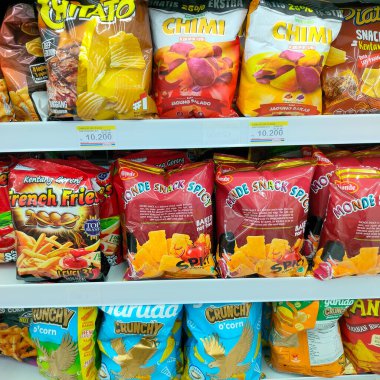 Indomaret, Tarakan: 27 Temmuz 2023 - Tarakan ana yolunun kenarındaki Tarakan bölgesinde yer alan Indomaret minimarket, vitrinlerden biri çeşitli abur cuburlar satıyor