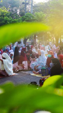 Sidoarjo, East Java, Indonesia - April 10 2024: Many people women pray Eid Mubarak in the mosque yard. clipart