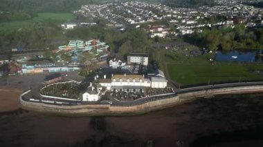 Goodrington Sands, Devon, İngiltere: DRONE VİEWS: Su Sıçrayan Quaywest su parkı akıntıları, Premier Inn Oteli, Torbay VeloPark 'ın tümü B / g' de; Daireler l-r Young 'un Parkı' ndaki kayıkhane göllerini, Paignton 'un varoşlarını ortaya çıkarmak için.