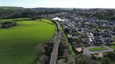 Broadbay, Torbay, Güney Devon, İngiltere Kingswear 'e giden buharlı tren. Torbay buharlı treninde Kingswear 'e doğru giden buharlı bir lokomotifin dikiz görüntüsü. Resmin sağında kumsaldaki evler var..