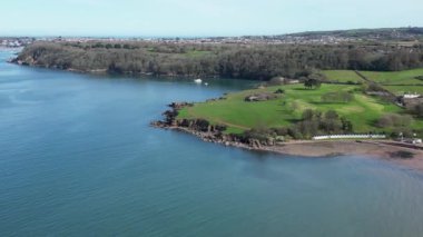 Broadbay, Torbay, Güney Devon, İngiltere: DRONE VİEWS: Arka planda Elberry Cove olan Torbay burnu etrafında İHA daireleri; buruna doğru yakınlaş ve koy; Broadbeach 'i ortaya çıkaran burundan uzaklaş.