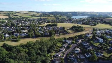 Broadston, Güney Devon, İngiltere: DRONE AERIAL VİEWS: İHA, Galmpton Warborough Common 'a doğru Broadmarket Broadsand evleri üzerinden uçar;.