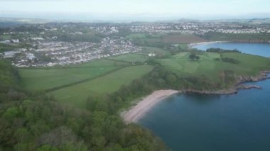 Elberry Cove, Torbay, Devon, İngiltere: DRONE AERIAL VİEWS: İnsansız hava aracı Elberry Cove sahiline doğru uçuyor ve Torbay sahili, Fields; Evler ve Broadsand plajı.