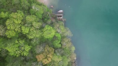 Elberry Cove, Torbay, Devon, İngiltere: DRONE AERIAL VİEWS: İnsansız hava aracı, yeşil ağaç tepeleri ve akuamarin denizinin zıt renklerini doğrudan ve tepeden görüyor; Viktorya dönemi hamamları (hamam); yüzücülerle Elberry Körfezi; yakın tarlaları;.
