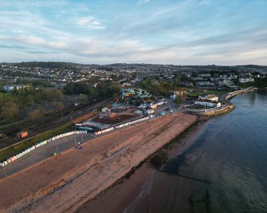 Goodrington Sands, Torbay, Güney Devon, İngiltere: DRONE AERIAL VİEW: South Sands plajı, renkli sahil kulübeleri ve deniz manzarası.