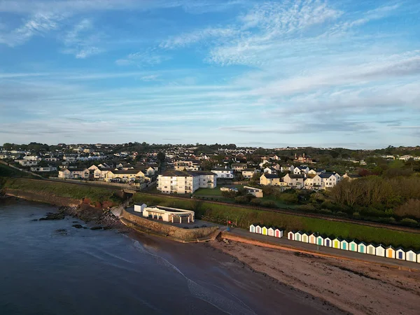 Goodrington, Torbay, South Devon, England: DRONE AERIAL VIEW: Goodrington South Sands cafe and shelter, the sea, nearby houses, apartments and flats, Torbay steam railway line and the Torbay coastline