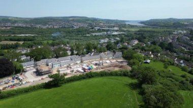 Newton Abbot, Güney Devon, İngiltere: DRONE AERIAL VİEWS: Kısmen inşa edilmiş evler, tamamlanmış evler ve vakıflarla yeşil kuşak üzerinde yeni bir inşaat sahası. Dartmoor Milli Parkı 'na doğru bakan kırsal bölge (Bölüm 5).