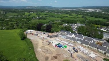 Newton Abbot, Güney Devon, İngiltere: DRONE AERIAL VİEWS: Kısmen inşa edilmiş evler, tamamlanmış evler ve vakıflarla yeşil kuşak üzerinde yeni bir inşaat sahası. Dartmoor Milli Parkı 'na doğru bakan kırsal bölge (Bölüm 3).