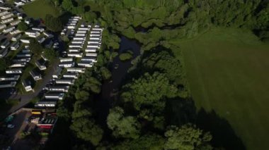 Clennon Lakes, Paignton, Torbay, Devon, İngiltere insansız hava aracı Clennon Gölleri üzerinden Clennon Vadisi ormanlarına doğru uçuyor. Resmin solunda Hoburne Devon Körfezi Holiday Parkı 'ndaki pansiyonlar, sağda ise Clennon Vadisi oyun alanları yer alıyor..