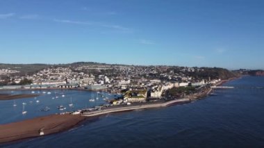 Teignmouth, Güney Devon, İngiltere: DRONE AERIAL ViEW: İnsansız hava aracı Teignmouth ticari rıhtımına (mavi binalar, resmin solunda), Teignmouth kasabasına, Teignmouth Nehir Halkı ve Teignmouth İskelesi 'ne doğru uçar.