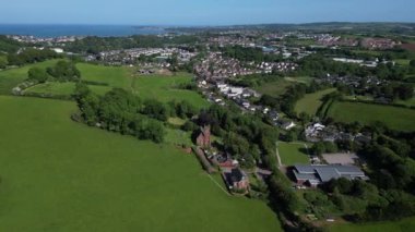 Collaton St Mary, Güney Devon, İngiltere: DRONE VİEWS: İHA, Totnes Yolu 'nu gösteren Collaton Saint Mary & St. Mary Kilisesi köyüne doğru uçuyor.