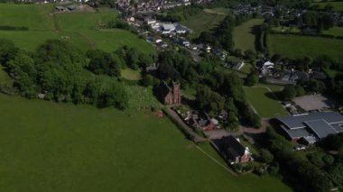 Collaton St Mary, Güney Devon, İngiltere: DRONE AERIAL VİEWS: İHA St Mary kilisesine ve Collaton Saint Mary köyüne doğru iniyor ve yakınlaşıyor.