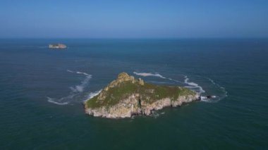 Torquay, Torbay, Güney Devon, İngiltere: DRONE AERIAL VİEWS: İnsansız hava aracı Thatcher Kayası 'na doğru uçar (arka planda Orestone Kayası ile birlikte); insansız hava aracı Thatcher Kayası' na tepeden bakmak için eğilir.