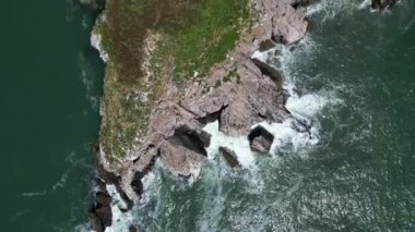 Torquay, Torbay, Güney Devon, İngiltere: DRONE AERIAL VİEWS: İnsansız hava aracı Thatcher Kayası üzerinden güneyden kuzeye uçarak adanın, dalgaların ve denizin doğrudan yukarıdan görüntüsünü verir (Klip 1)).