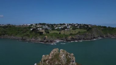 Torquay, Torbay, Güney Devon, İngiltere: DRONE AERIAL VİEWS: İHA Thatcher Kayası 'nın en yüksek zirveleri üzerinden güney-kuzeyden yükselir, sonra Thatcher Point ve anakaraya doğru uçarken alçalır.