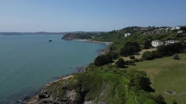 Torquay, Torbay, Güney Devon, İngiltere: DRONE AERIAL VİEWS: İHA Thatcher Point üzerinde ön planda ve Torbay kıyı şeridi boyunca Meadfoot Beach 'e doğru uçar.