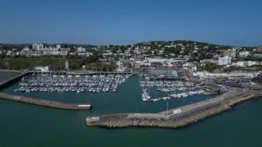 Torquay, Torbay, Güney Devon, İngiltere: DRONE VİEWS: Yüksek açı, Torquay Marina girişini ön görüş; liman duvarı, İngiliz Riviera Tekerleği ve arka planda Torquay kasabasını gösteren İHA izleri (Bölüm 2)).