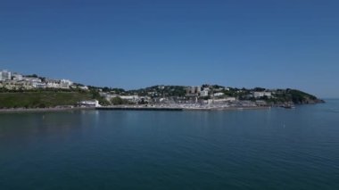 Torquay, Torbay, Güney Devon, İngiltere: DRONE VİEWS: İHA, Prenses Tiyatrosu (resmin solunda), İngiliz Riviera Tekerleği (solda) ve limana giriş yapan iki eğlence teknesi ve limana demirlemiş yatları gösteren Torquay Marina 'ya doğru yükselir..