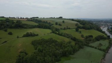 Totnes, Güney Devon, İngiltere: DRONE VIEWS: İnsansız hava aracı nehir dartı, vadisi, tepeleri ve ormanlık üzerinde güneyden kuzeye uçarak uzaktaki Totnes kasabasını görüyor (Bölüm 2)).