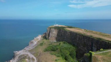 Berry Head, Güney Devon, İngiltere: DRONE AERIAL VieWS: İnsansız hava aracı deniz feneri ve onsekizinci yüzyıl tahkimatı ve eski bir kireç taşı ocağı ile Berry Head 'e doğru uçuyor..