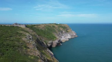 Berry Head, Güney Devon, İngiltere: DRONE AERIAL VİEWS: İnsansız hava aracı engebeli kireçtaşı uçurumlarının üzerinden deniz feneri ve onsekizinci yüzyıl tahkimatlarıyla Berry Head 'e doğru uçuyor..