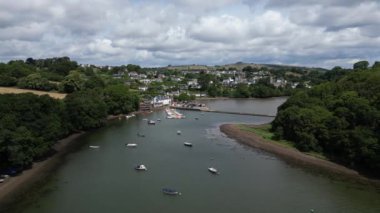 Stoke Gabriel, Güney Devon, İngiltere: DRONE AERIAL VİEWS: İnsansız hava aracı nehir dartlarında demirlemiş teknelerin üzerinden uçuyor ve arkada Stoke Gabriel köyüyle birlikte Mill Pond weir 'e doğru ilerliyor.