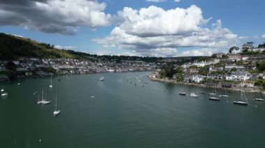 River Dart, Dartmouth, Güney Devon: DRONE VİEWS: DRON nehir dartının Kingswear tarafına doğru uçar, demirli yatları ve nehri gezen turistik tekneleri gösterir; nehrin sol tarafında Dartmouth kasabası bulunur..