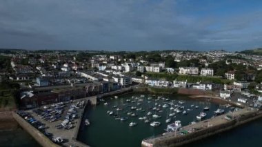 Paignton, Torbay, Güney Devon, İngiltere: İHA, arka planda Paignton Limanı girişi, deniz ve Paignton kasabasını gösteren tekne ve yatlardan uzaklaşıyor. Paignton popüler bir tatil beldesidir (Klip 1).