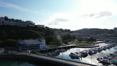 Torquay, Torbay, Güney Devon, İngiltere: DRONE VİEWS: İngiliz Riviera Tekerleği, Prenses Tiyatrosu ve yat marinadaki tekneleri gösteren İHA Torquay Marina 'dan geri çekilir. Torquay turistler ve tatilcilerin olduğu popüler bir sahil beldesi.