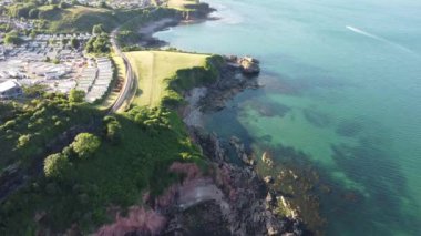 Torbay, Güney Devon, İngiltere: DRONE VİEWS: Drone Armchair Cove üzerinde uçuyor ve tren yolunun solundaki Waterside Park tatil parkı ile Saltern Cove 'a doğru. Torbay, İngiliz Rivierası olarak bilinir ve İngiltere 'nin en büyük turistik tatil beldesidir..