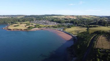 Broadbay, Torbay, Güney Devon, İngiltere: DRONE VİEWS: İHA kıyı şeridi üzerinde uçuyor ve tren yolu Broadsand plajına doğru gidiyor. Torbay bölgesi İngiliz Rivierası olarak bilinir ve İngiltere 'de büyük bir tatil beldesi ve turizm merkezidir..