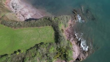 Oyster Cove, Torbay, Devon, İngiltere: DRONE AERIALS: İnsansız hava aracı kamera yeşil bir yerden yukarı doğru eğildi ve Oyster Cove 'daki uçurumlar Torbay' ı ortaya çıkarmak için geri çekildi. Torbay, güzel kıyı manzarası nedeniyle popüler bir İngiltere tatil beldesi..