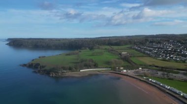 Broadbay, Torbay, Güney Devon, İngiltere: DRONE VİEWS: İHA Broadsand sahili ve Torbay kıyı şeridini göstermek için sahil kulübelerinden uzaklaşıyor. Torbay popüler bir İngiltere tatil beldesidir (Clip 3).